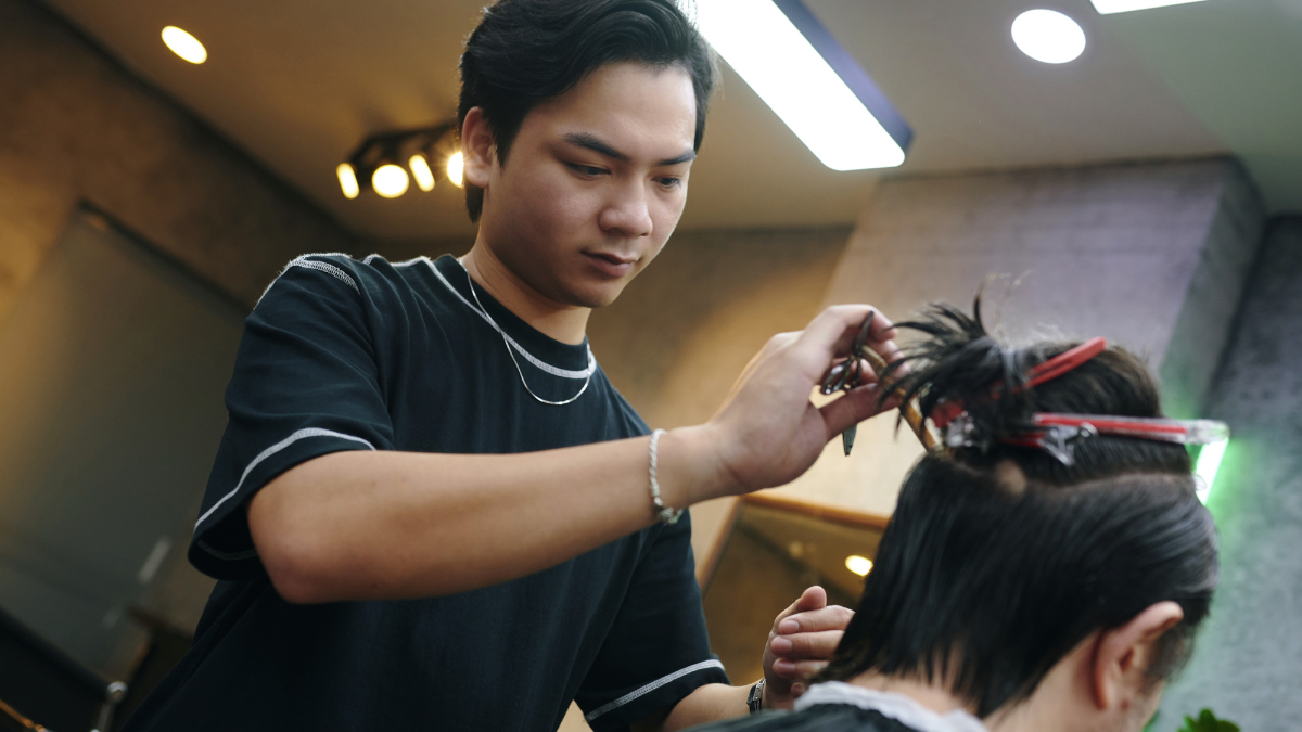 A barber discusses the barbershop rules with a client while cutting his hair.