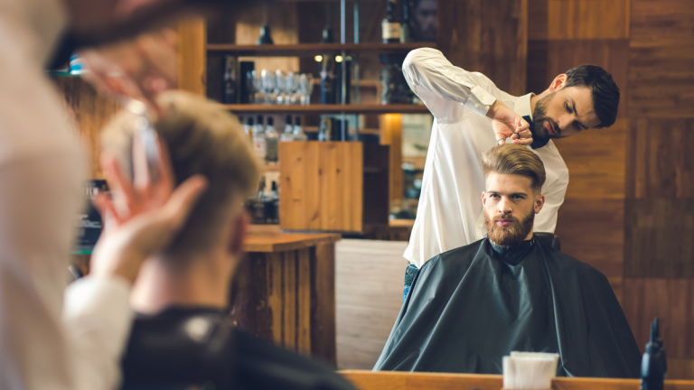 A customer gets his hair buzzed as his barber give his head a quick trim while discussing his money-saving barbershop hacks.