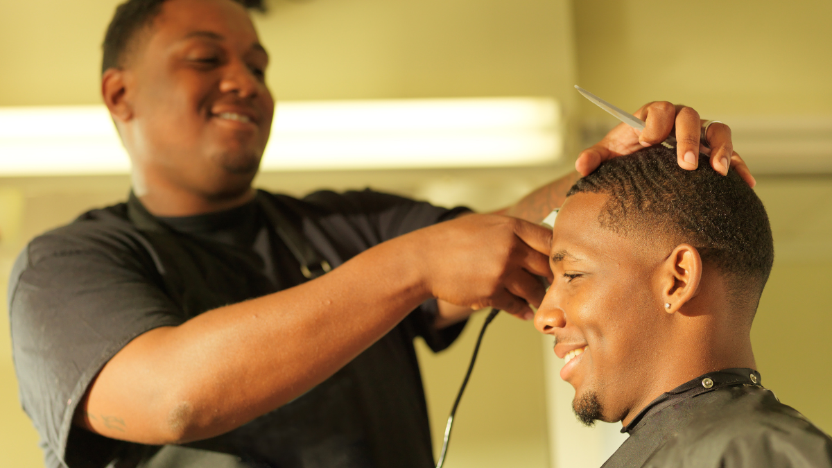 A Black barber cuts a client's hair during Black History Month.