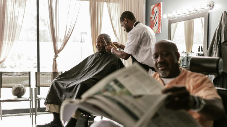 Two black barbers cut their clients' hair during Black History Month.