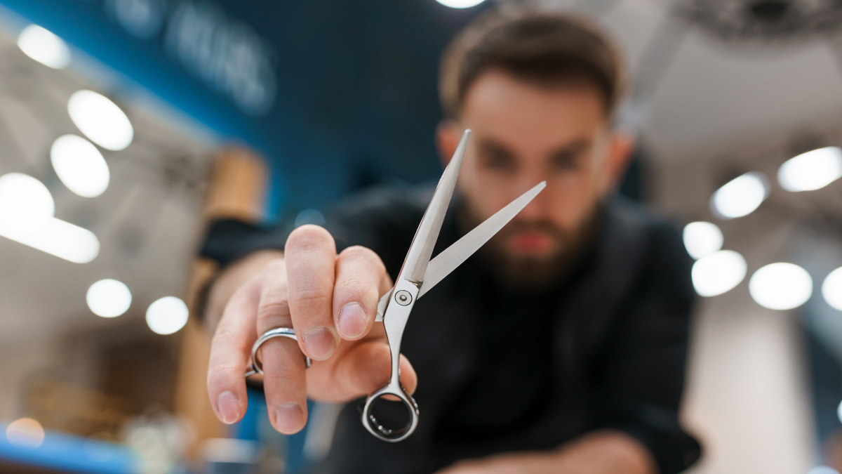 A barber shows off his new shears for a barber content creator video he's making.