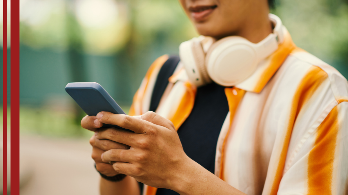 A barber drafts an email on his phone using the best email marketing tips for barbers.